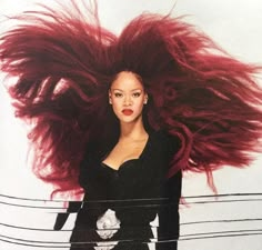 a woman with long red hair standing in front of a white wall wearing black clothes