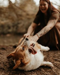 a woman is petting a dog on the ground