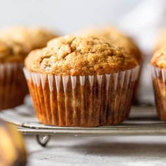 muffins on a cooling rack with bananas in the background