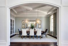 a dining room with a table and chairs under a chandelier hanging from the ceiling