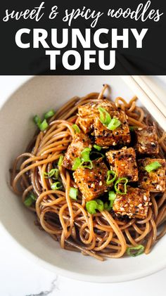 a white bowl filled with noodles and tofu on top of a marble countertop