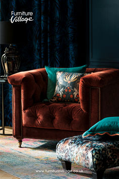 a living room with a red couch and colorful throw pillows on it's back