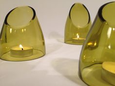 two yellow vases sitting next to each other with a lit candle in the middle