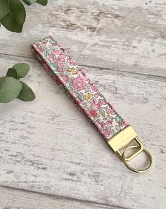 If you're a fan of Liberty of London's iconic prints you'll love these pretty Tana Lawn fabric wristlets in 'Betsy Ann' in pink.  The perfect accessory to hold your house or car keys, making them easier to find in the bottom of your bag, and the fabric loop will sit securely around your wrist. Measuring 15cm from the fabric end to the top of the metal fob (excluding the split ring) by 2.5cm wide.  The fabric has been interfaced with a soft fusible fleece giving them structure while retaining the Student Flat, Iconic Prints, Fabric Key Fob, Fusible Fleece, Key Fob Wristlet, Key Fobs Wristlet, Lawn Fabric, Liberty Of London, Split Ring