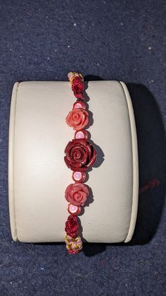 red shell rose with 3d beads and 2 pink shell rose on a red hand made bracelet. for the rose in your life Adjustable Rose Red Bracelet For Gift, Adjustable Rose Red Bracelet As Gift, Adjustable Rose Red Bracelet Perfect For Gifts, Adjustable Rose Red Bracelets As Gift, Red Flower Bracelets For Valentine's Day, Rose Color Bracelets For Valentine's Day, Rose Bracelets For Valentine's Day, Adjustable Rose Red Flower Jewelry, Adjustable Rose Bracelet For Gift