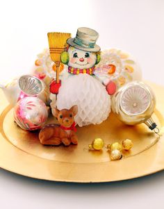 a gold tray with some ornaments and a small dog on the plate next to it