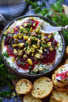 a bowl of hummus with cranberry sauce and pistachios