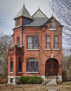 an old red brick house with two towers on the top and one story above it