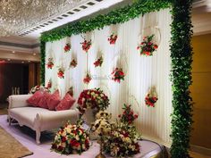 a living room decorated with flowers and greenery on the wall, along with two couches