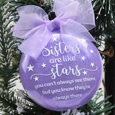 a purple ornament hanging from a christmas tree that says sisters are like stars you can't always see them, but you know they're always there