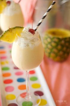 two glasses filled with ice cream and pineapple on a polka dot tablecloth covered tray