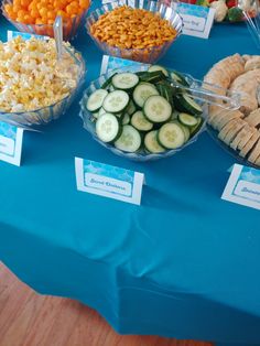 a table topped with bowls filled with different types of food next to plates of crackers and cucumbers