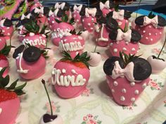 some chocolate covered strawberries with minnie mouse decorations on them are sitting on a table