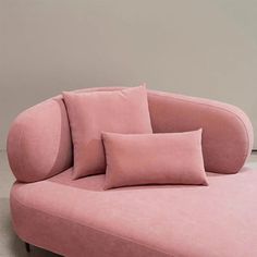 a pink couch with two pillows on it