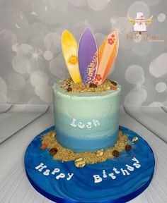 a birthday cake decorated with surfboards and sand