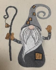 an embroidered image of a wizard holding a staff and wearing a hat with two bells