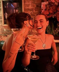 two women sharing a laugh while holding wine glasses