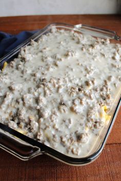 a casserole dish with meat and gravy in it on a wooden table