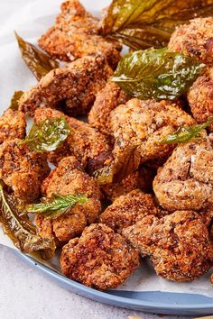 fried food on a plate with some leaves