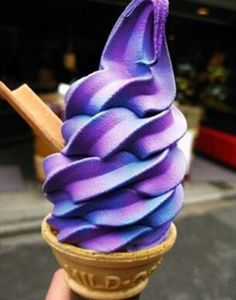 an ice cream cone with purple icing in it