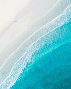 an aerial view of the water and sand