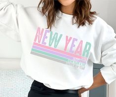 a woman wearing a white sweatshirt with the words new year on it