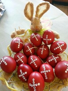 a basket full of red eggs with bunny ears on it and some other decorations in the background