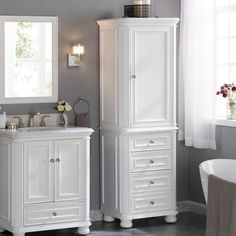 a bathroom with a sink, mirror and white cabinet in it's center area