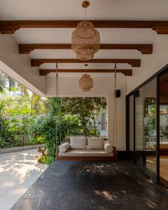 a porch with a couch and hanging lights