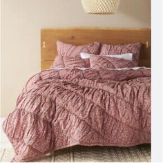 the bed is made with pink bedspread and pillows