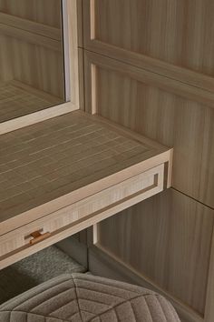 a close up of a mirror on a wooden cabinet with drawers in the back ground