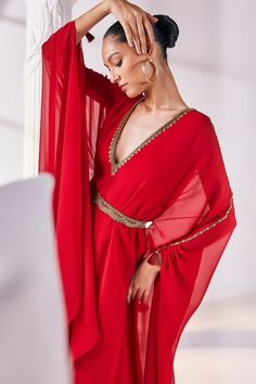 Red layered kaftan dress with an embroidered neckline. Paired with a scallop edged embellished belt. - Aza Fashions Glamorous Dress With Dupatta For Eid, Glamorous Eid Dress With Dupatta, Eid Party Dresses With Cape Sleeves, Festive V-neck Dresses With Sheer Dupatta, Bollywood Embellished Dress With Cape Sleeves, Festive Maxi Dress With Draped Sleeves, Red Long-sleeved Kaftan For Party, Red Long Sleeve Kaftan For Party, Bollywood Style Hand Embellished Dress With Cape Sleeves