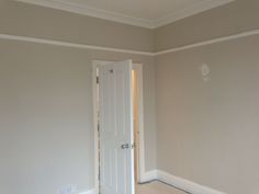 an empty room with a white door and hard wood floor