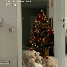 two teddy bears wrapped in blankets are sitting on a bed next to a christmas tree