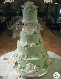 a wedding cake sitting on top of a table covered in white and green frosting