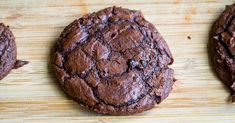 three chocolate cookies sitting on top of a wooden table