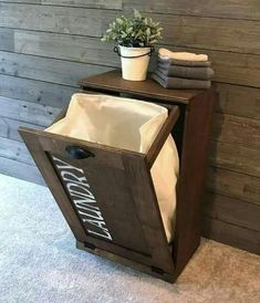 a wooden cabinet with towels and a potted plant