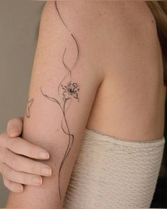 a woman's arm with a flower tattoo on the left side of her arm