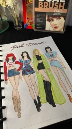 a drawing of three women in different outfits on a table next to books and magazines