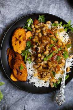 a black plate topped with rice and beans next to two bowls filled with fried plantains