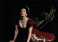 an autographed photograph of a woman in a red dress