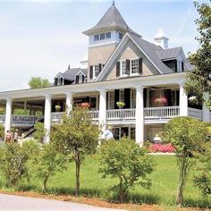 a large white house sitting on top of a lush green field