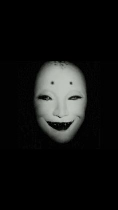 a creepy mask with an evil smile on it's face is shown in the dark