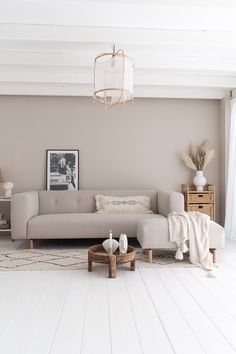 a living room filled with furniture and a chandelier hanging from the ceiling above