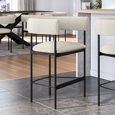 four white chairs sitting in front of a counter top with a bar stool next to it