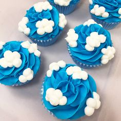 cupcakes with blue frosting and white flowers on them