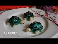 three little turtles on a white plate with flowers in the background