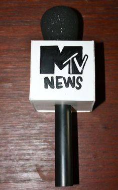 a microphone that is sitting on top of a wooden table next to a news box