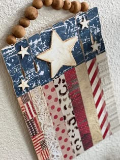 an american flag with stars and stripes is hanging on the wall next to a bead necklace