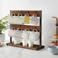 a rack with cups and mugs hanging from it's sides on a counter